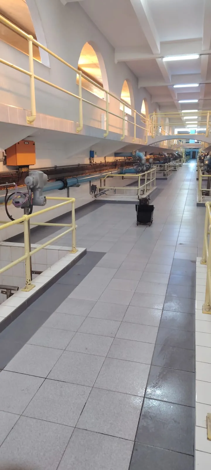 The filter-house gallery — arched bays, tiled walkways and rows of actuated pipework