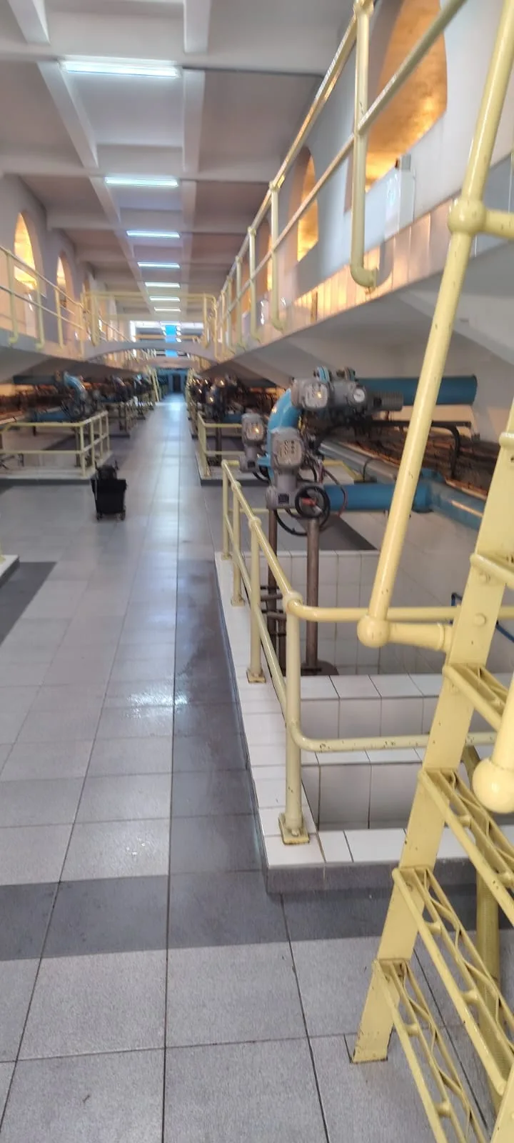 Walkway view down the filter-house gallery, actuators along the chamber edge